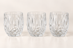 Three clear faceted glass tumblers on a neutral studio background